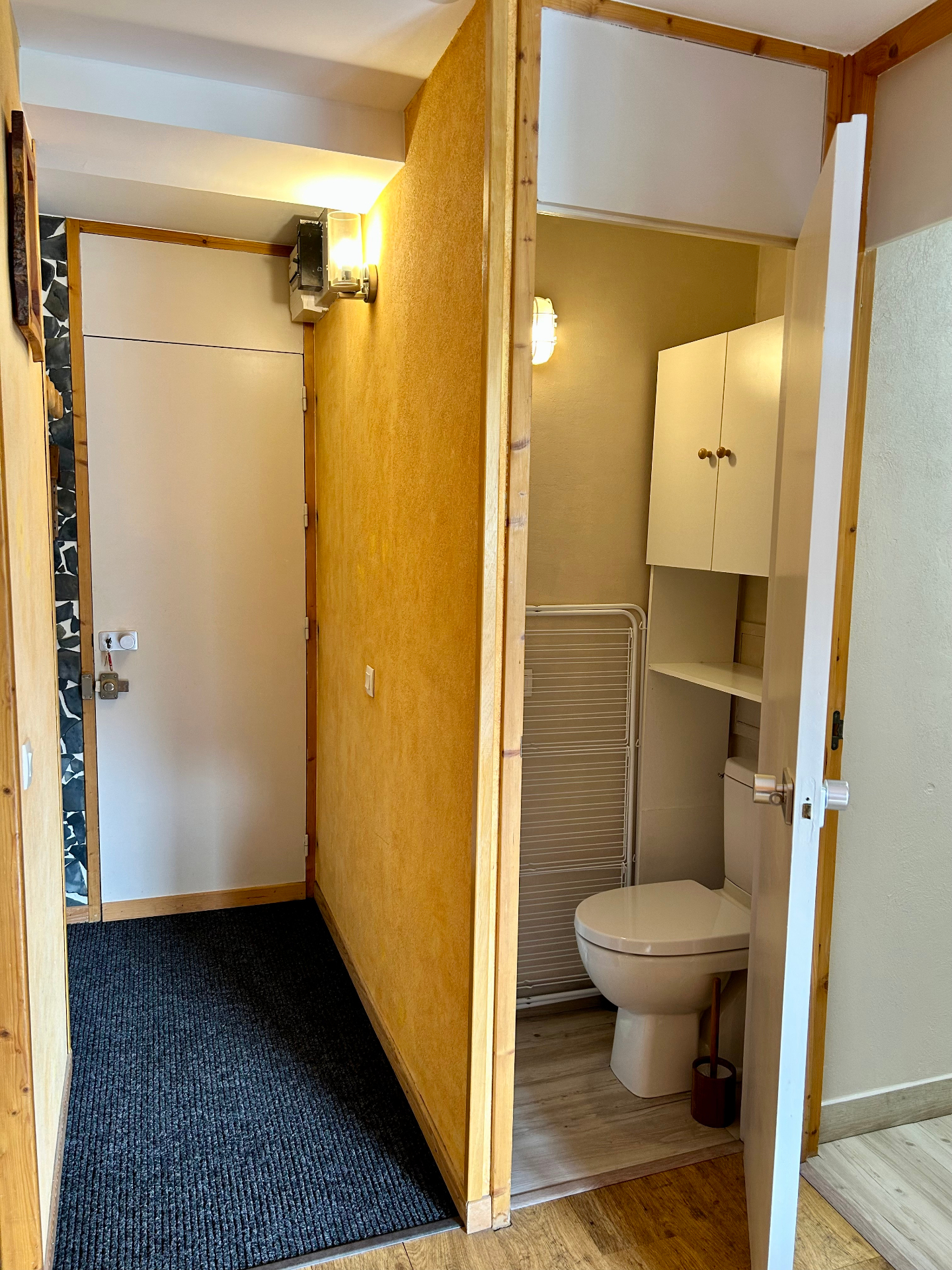 Coin nuit de la chambre avec rideaux en lin, tabouret en bois et décoration montagnarde rouge