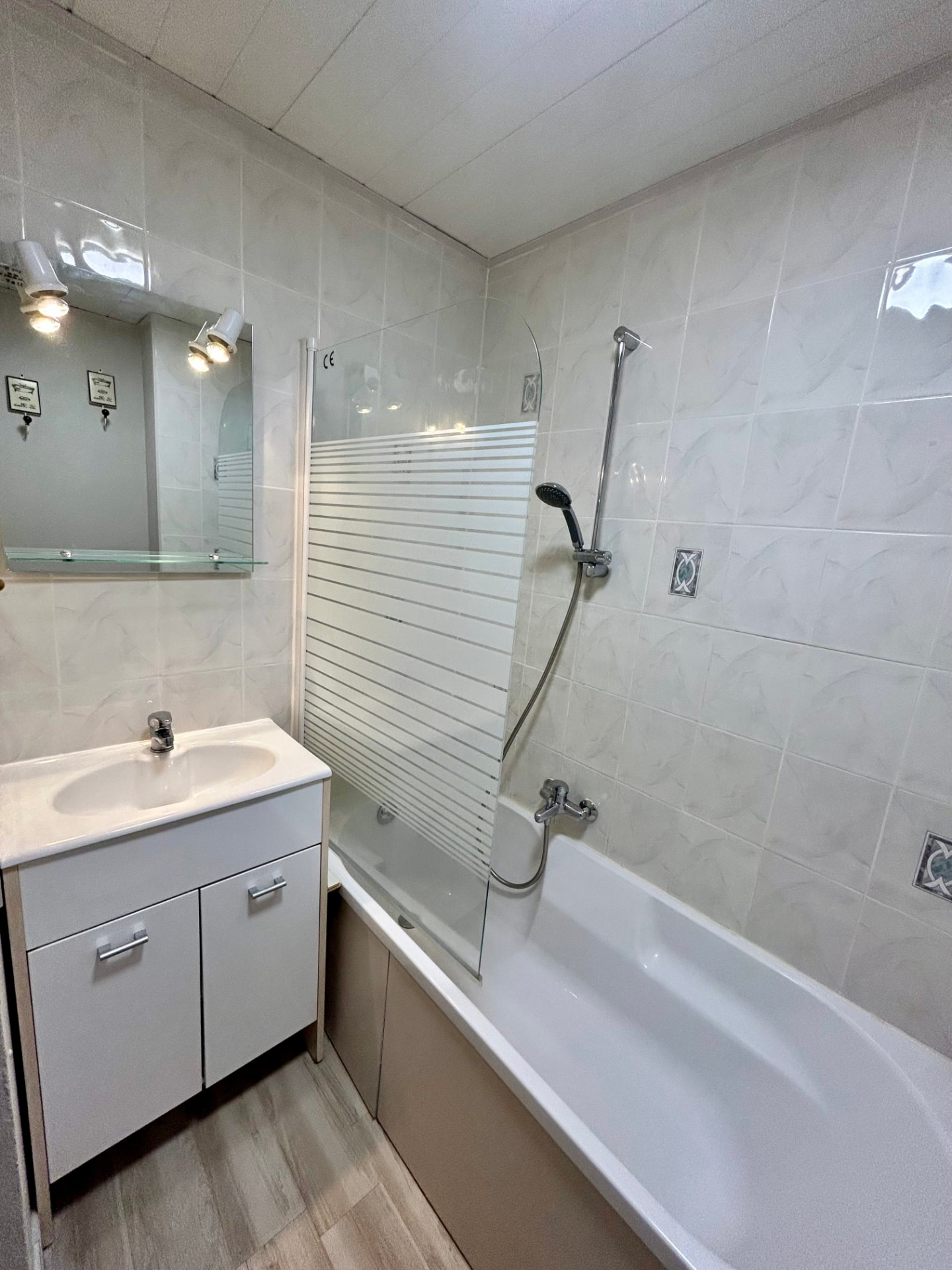 Lit double avec tête de lit en bois clair et couette brodée de motifs rouges